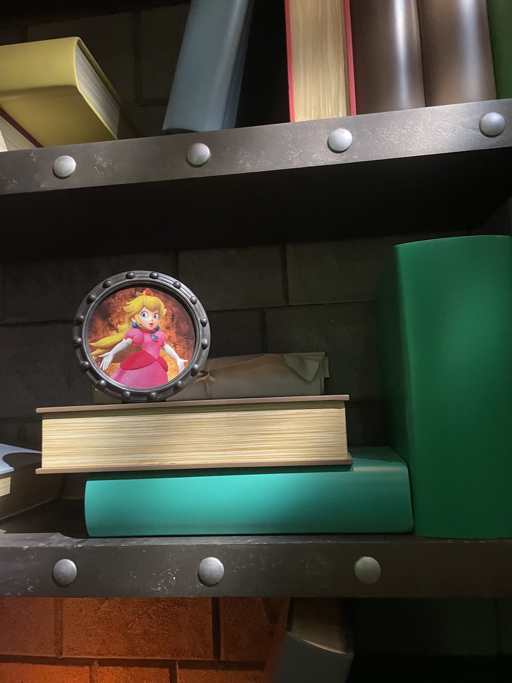 A Princess Peach charm tucked on a shelf