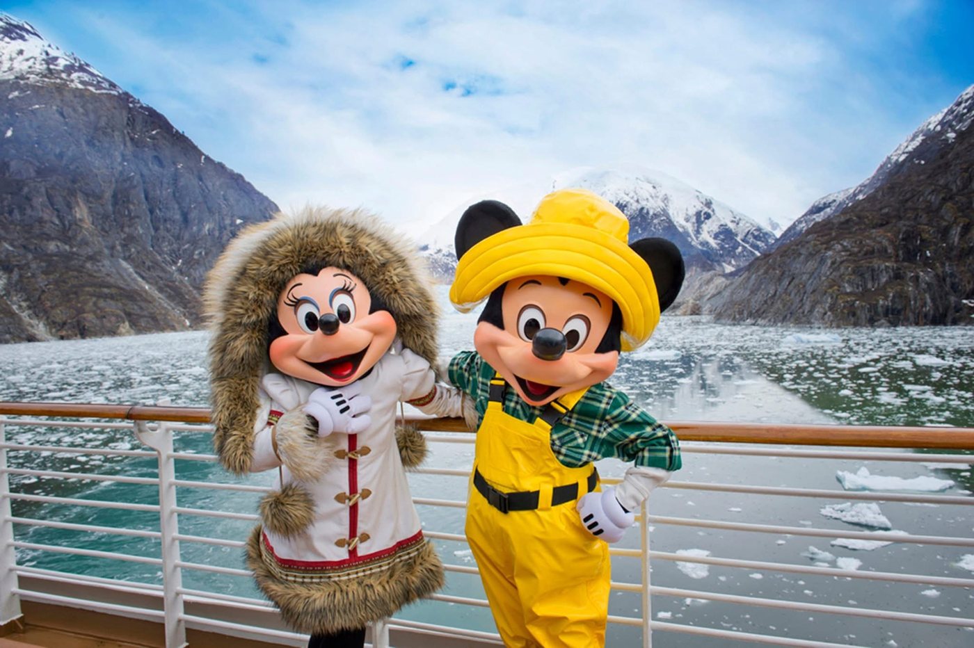 Mickey and Minnie in cold-weather gear on deck in an Alaskan fjord