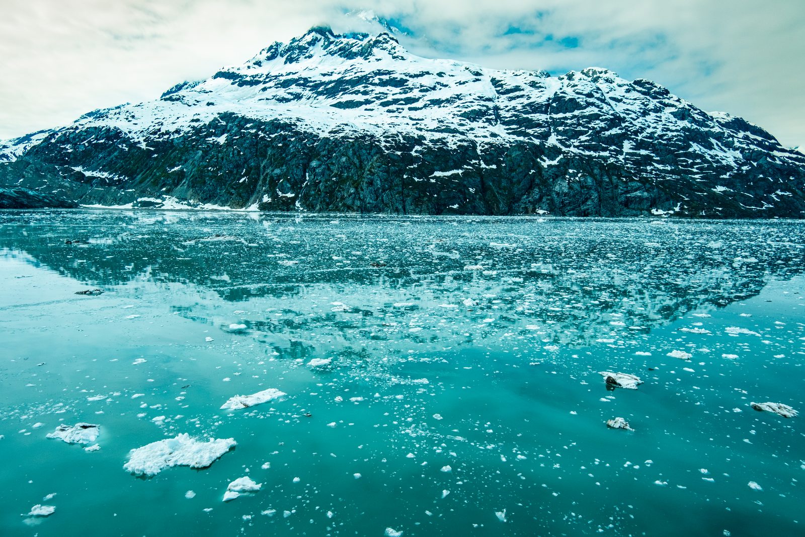 Snow-capped mountains over the glacial ice of Alaska's Glacier Bay