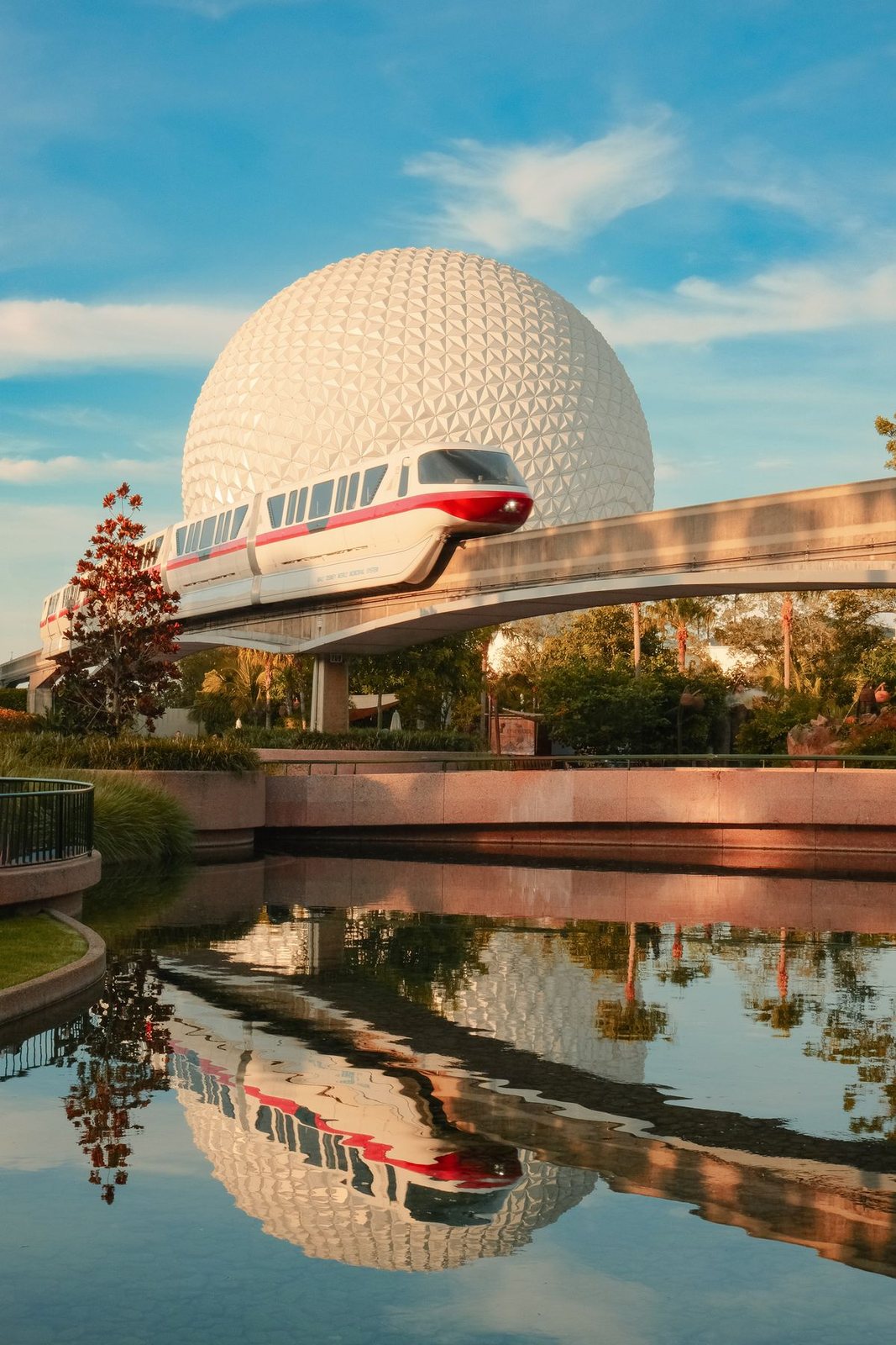 The monorail glides past Spaceship Earth at golden hour